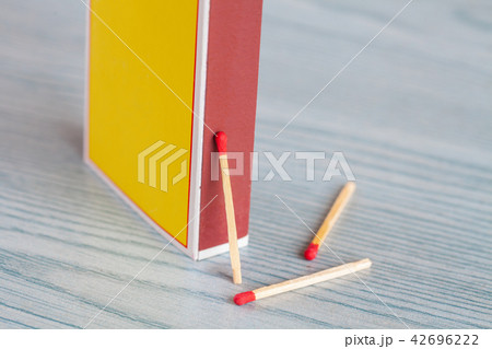 Matchstick out of matchbox on color wood table. Matchstick out of matchbox on color wood table. 42696222