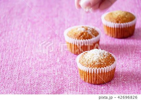 Muffins with coconut powder. Pink background 42696826