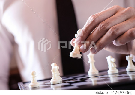 Hand of confident businessman use king chess piece white playing Hand of confident businessman use king chess piece white playing 42697266
