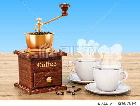 Manual coffee grinder with cup of coffee 42697994