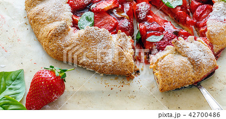 Cut homemade cake with strawberries and basil. Cut homemade cake with strawberries and basil. 42700486
