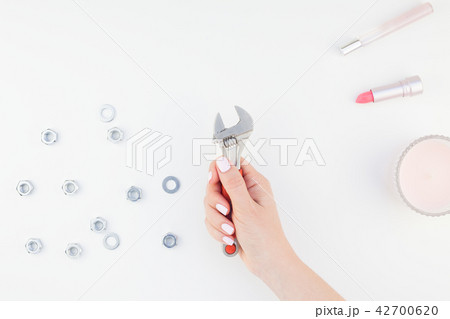Female hand holding spanner on white background 42700620