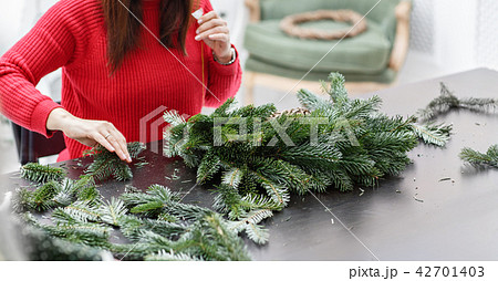 Manufacturer of Christmas wreath from branches of pine for holiday. Master class on making 42701403