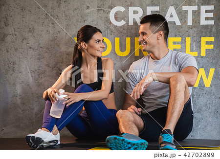 Positive guy is communicating with girlfriend in gym Positive guy is communicating with girlfriend in gym 42702899