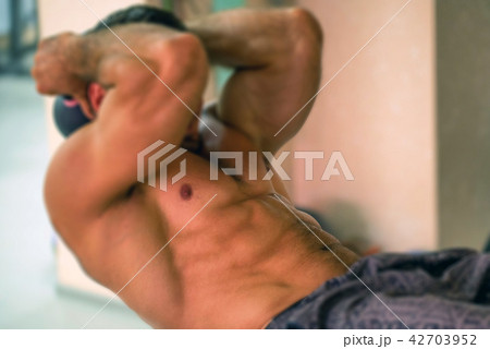 Healthy man exercising abdominals Healthy man exercising abdominals 42703952