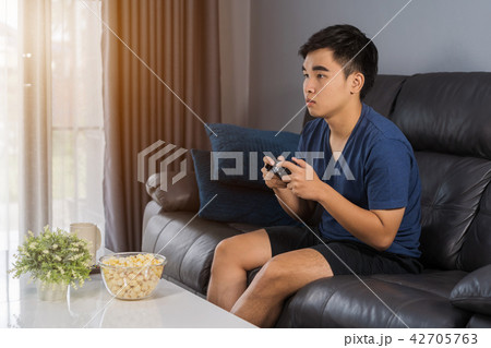 man playing video game with joystick in the living room 42705763
