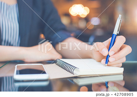 Business woman is taking notes on a note pad. Business woman is taking notes on a note pad. 42708905