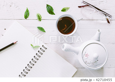 Cup of tea with book on  wooden table 42710455