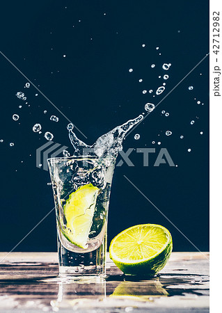 Lime slice falls into a glass with alcohol Lime slice falls into a glass with alcohol 42712982