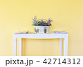 white basket on white table with yellow wall 42714312