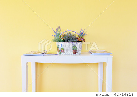 white basket on white table with yellow wall 42714312