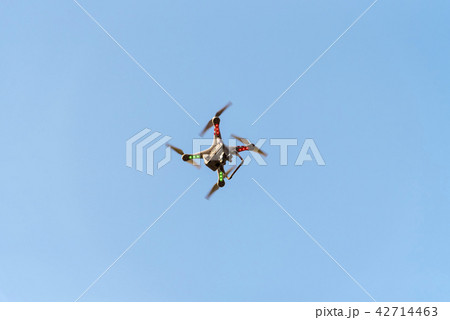 Drone with camera on blue sky. Drone with camera on blue sky. 42714463