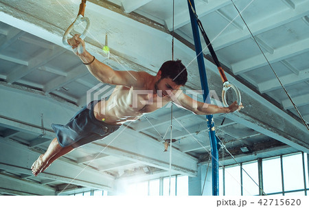The sportsman during difficult exercise, sports gymnastics The sportsman during difficult exercise, sports gymnastics 42715620