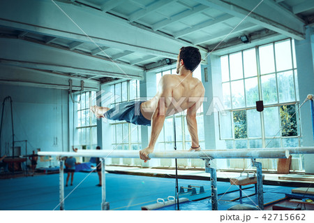 The sportsman during difficult exercise, sports gymnastics The sportsman during difficult exercise, sports gymnastics 42715662