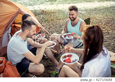 Party, camping of men and women group at forest. They relaxing and eating barbecue 42715689