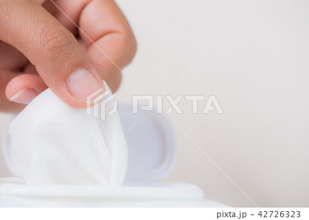 Woman hand holding wet wipes from package. 42726323