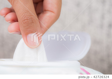 Woman hand holding wet wipes from package. 42726324