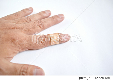 左手人差し指に貼った絆創膏の写真素材
