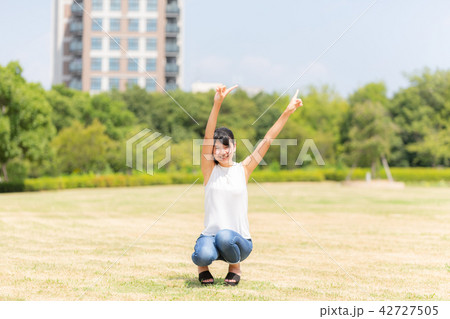 公園で空を指さす女性 42727505