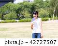 うちわで扇ぐ女性 42727507