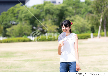 うちわで扇ぐ女性 42727507