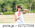 うちわで扇ぐ女性 42727508