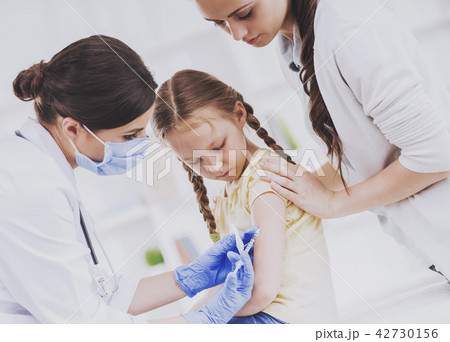 Young Doctor in Mask Vaccinating Little Girl. 42730156