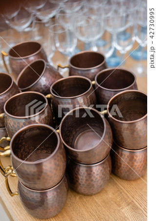 Moscow mule cocktail copper mugs on a counter top. Outdoor party. The work of the bartender Moscow mule cocktail copper mugs on a counter top. Outdoor party. The work of the bartender 42730995