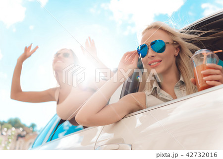 Cute Laughing Young Woman Hanging out from Car. 42732016