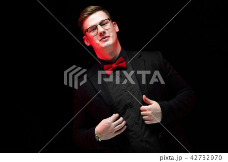 Portrait of confident handsome elegant responsible businessman holding hands on his jacket on black 42732970
