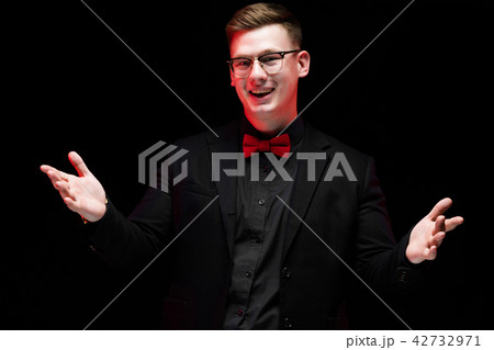 Portrait of confident handsome happy elegant responsible businessman with open hands on black 42732971