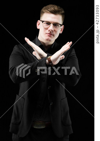 Portrait of confident handsome elegant responsible businessman showing stop gesture on black 42733093