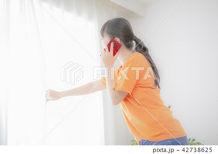 窓際で電話する女性 窓際で電話する女性 42738625