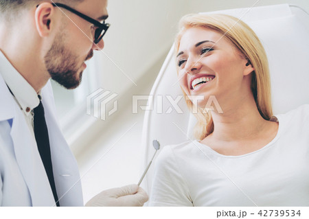 Young dentist talks with patient in dental clinic. Young dentist talks with patient in dental clinic. 42739534