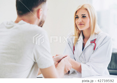 Woman Doctor and Male Patient in Hospital Office Woman Doctor and Male Patient in Hospital Office 42739592