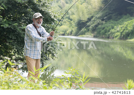 マス釣りをする日本人シニア男性の写真素材