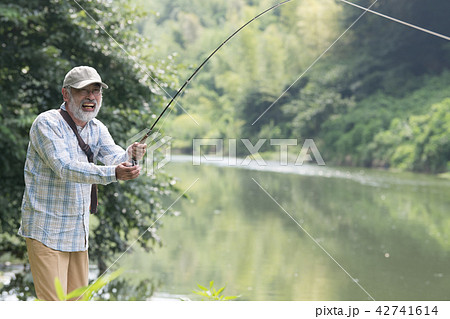 マス釣りをする日本人シニア男性の写真素材