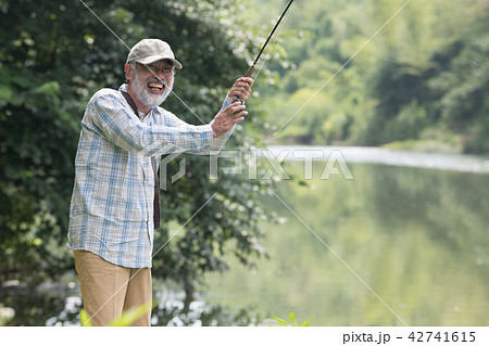 マス釣りをする日本人シニア男性の写真素材