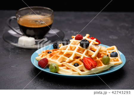Photo of cup of coffee with Belgian wafers with strawberries, raspberries 42743293