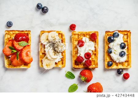 Traditional belgian waffles with whipped cream and fresh fruits  42743448