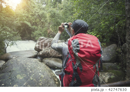 traveler photographing with backpack and enjoying traveler photographing with backpack and enjoying 42747630