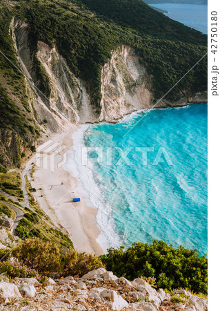 Alone tourist tent on famous Myrtos Beach. Big foam waves rolling towards the bay. Kefalonia, Greece Alone tourist tent on famous Myrtos Beach. Big foam waves rolling towards the bay. Kefalonia, Greece 42750180