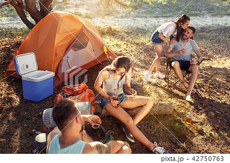 Party, camping of men and women group at forest. They relaxing, singing a song Party, camping of men and women group at forest. They relaxing, singing a song 42750763