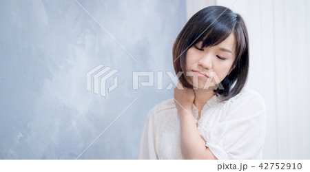 unhealthy female in white top with pain in neck 42752910