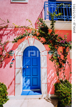 Assos village. Traditional lilac colored greek house with bright blue door and fucsie plant flowers Assos village. Traditional lilac colored greek house with bright blue door and fucsie plant flowers 42755901