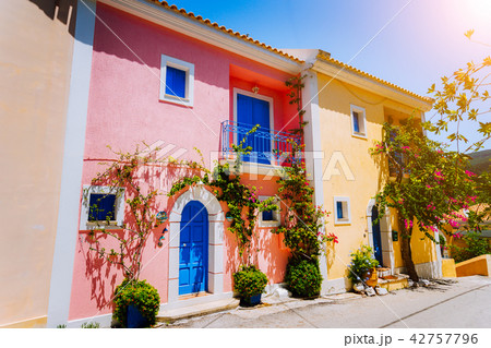 Assos village. Traditional colored greek houses with bright blue doors and windows. Blooming fucsia Assos village. Traditional colored greek houses with bright blue doors and windows. Blooming fucsia 42757796