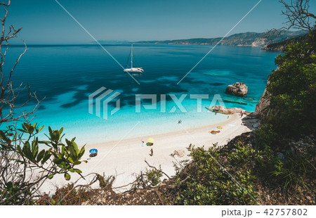 Fteri beach, Cephalonia Kefalonia, Greece. White catamaran yacht in clear blue sea water. Tourists 42757802