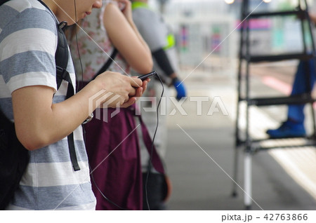 「駅のホームでながらスマホする男性」 42763866