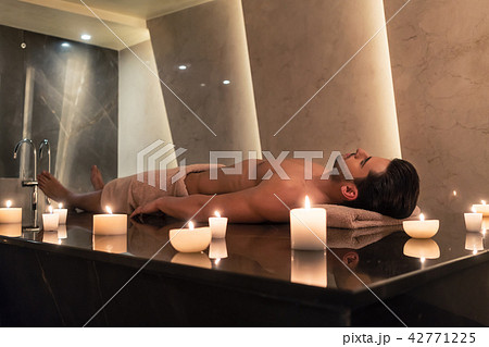 Man relaxing on massage table at Asian spa and wellness center 42771225
