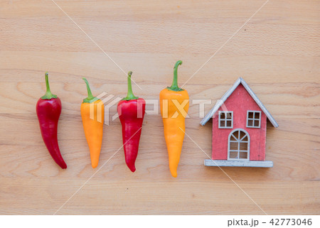 yellow and red peppers with toy house 42773046